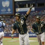 ST. PETERSBURG, FL - MAY 15:  Danny Valencia #26 of the Oakland Athletics, center, and teammate Coco Crisp #4 run around catcher Hank Conger #24 of the Tampa Bay Rays after both scoring off of Valencias two-run home run during the fifth inning of a game on May 15, 2016 at Tropicana Field in St. Petersburg, Florida. (Photo by Brian Blanco/Getty Images)