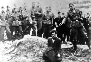 A member of Einsatzgruppe D is about to shoot a man sitting by a mass grave in Winniza, Ukraine, in 1942. Present in the background are members of the German Army, the German Labor Service, and former Hitler Youth.[107] The back of the photograph is inscribed "The last Jew in Vinnitsa".